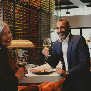 Man and woman enjoying food and wine at Domaine Serene Wine Lounge