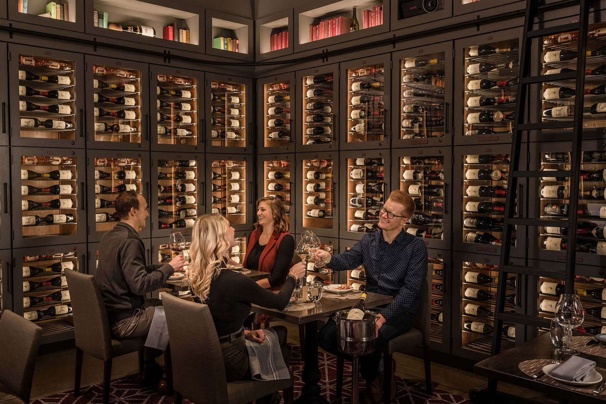 A group of people enjoying wine and food in the Library Room of Domaine Serene Wine Lounge in Lake Oswego