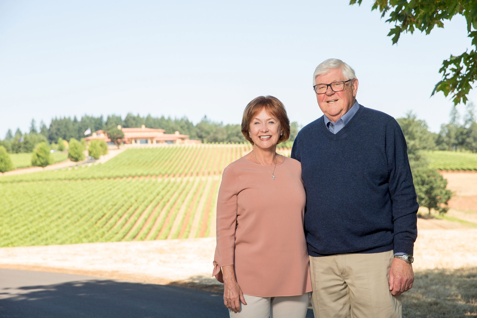 Grace and Ken standing in front of Domaine Serene vineyards