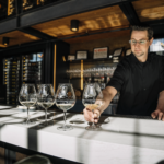 Employee pouring an Oregon wine tasting flight at Domaine Serene Wine Lounge Bend