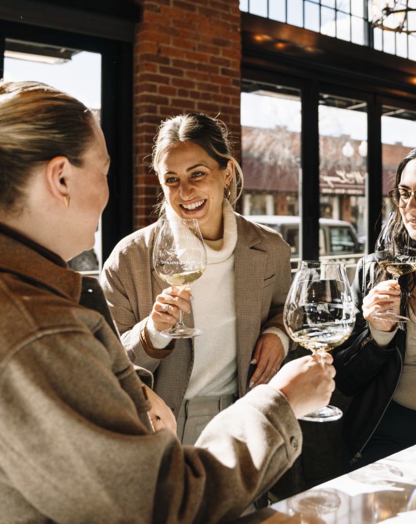 Women laughing and drinking wine at the Domaine Serene Wine Lounge Bend