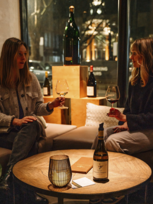 Women enjoying glasses of wine at a cozy table at Domaine Serene Wine Lounge Portland