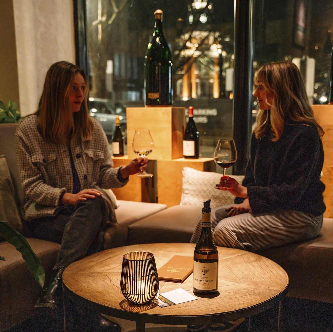 Women enjoying glasses of wine at a cozy table at Domaine Serene Wine Lounge Portland